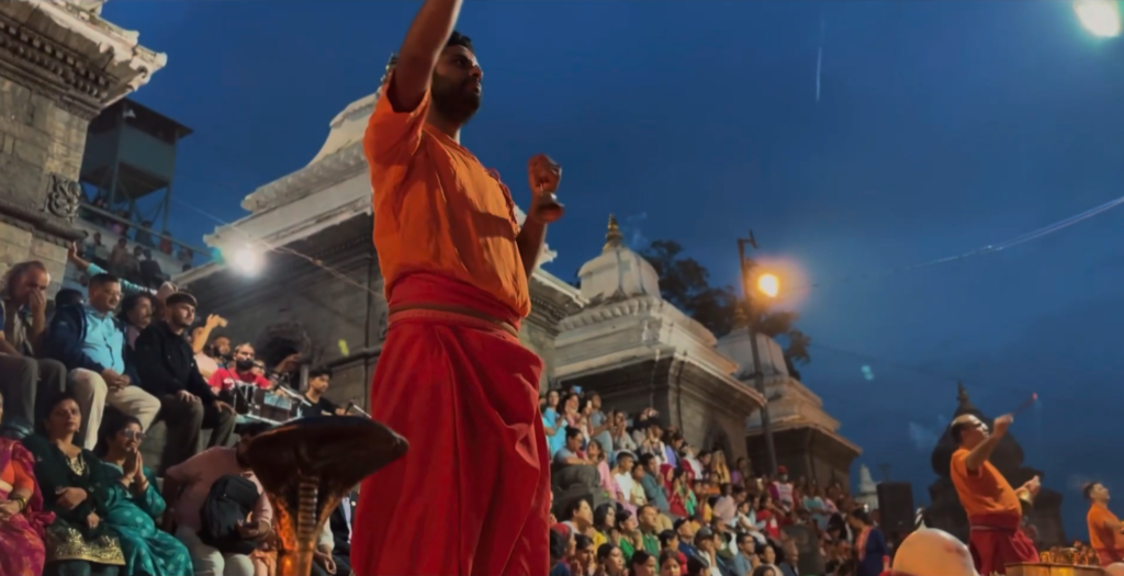 a-priest-during-pashupatinath-aarati-with-crowd-behind-scaled